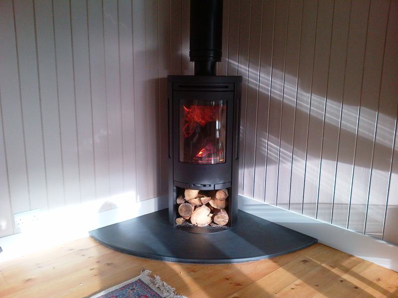 Corner wood burning stove with log storage