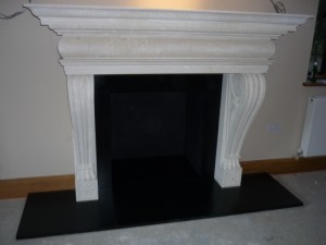 Large limestone fireplace mantel installation in Surrey