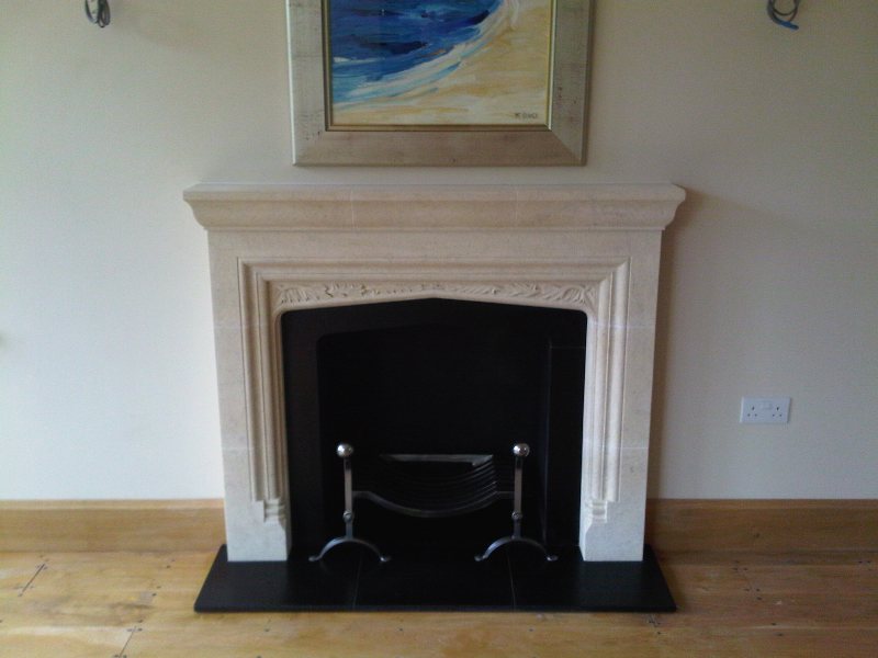 Stone ornate fireplace surround and fire dogs