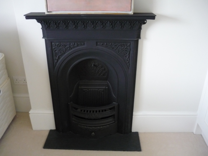 Small black cast iron fireplace surround in a bedroom