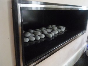 Black Granite Hole in the Wall Fireplace with pebbles