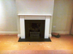 Limestone fireplace in Guildford with honed black granite slips and hearth