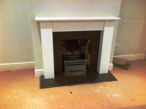 Limestone fireplace in Guildford with honed black granite slips and hearth
