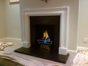 Limestone bolection fireplace with Morris basket and gas fire