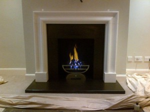 Completed Limestone bolection fireplace with Morris basket and gas fire