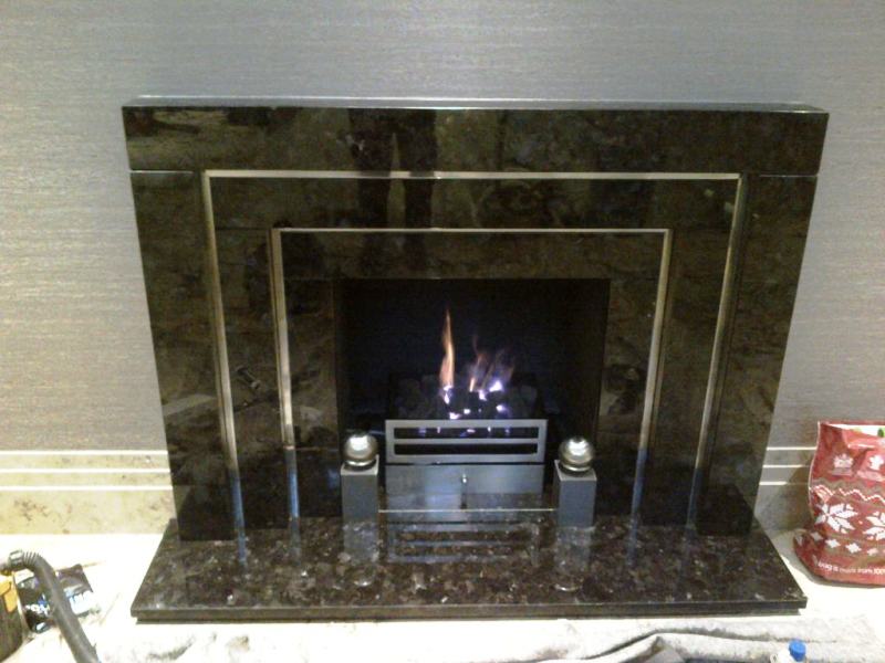 Black marble fireplace with chrome inlay and steel fire basket