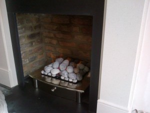 Flat Victorian limestone fireplace with large Zen basket with pebbles