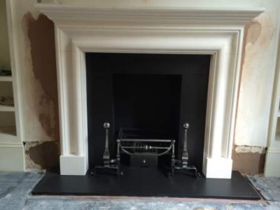 limestone bolection fireplace with Chesneys Morris basket and Burton firedogss